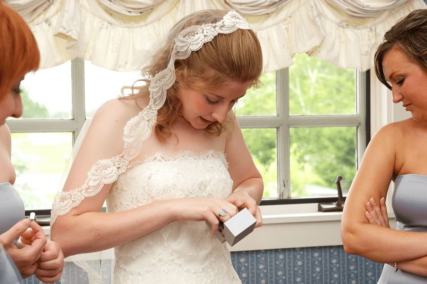 bride puts on earrings before wedding