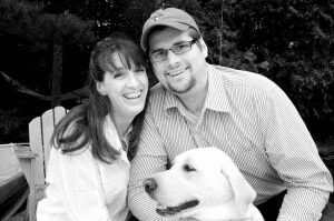 Maine bride and groom at a lake with their dog