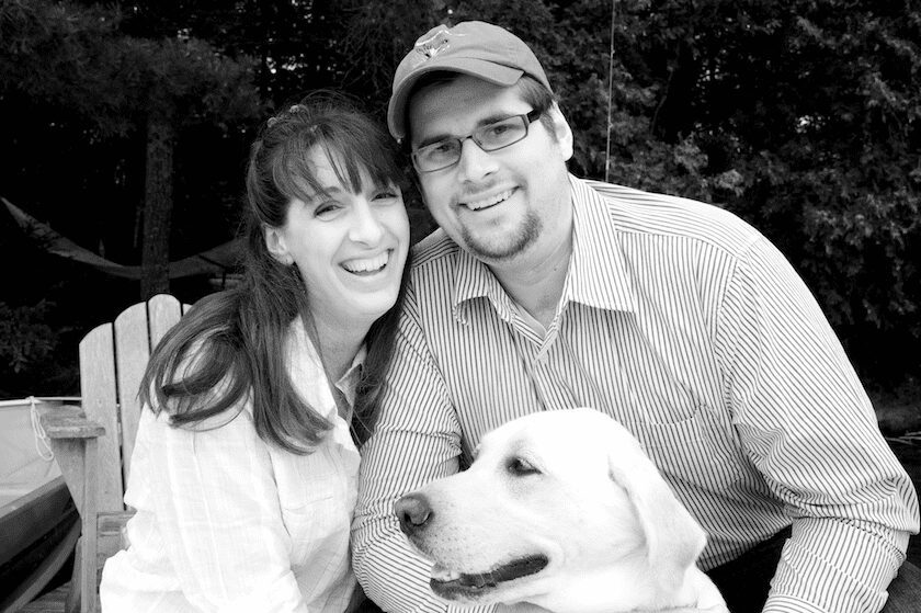 couple with dog Maine bride and groom at a lake with their dog