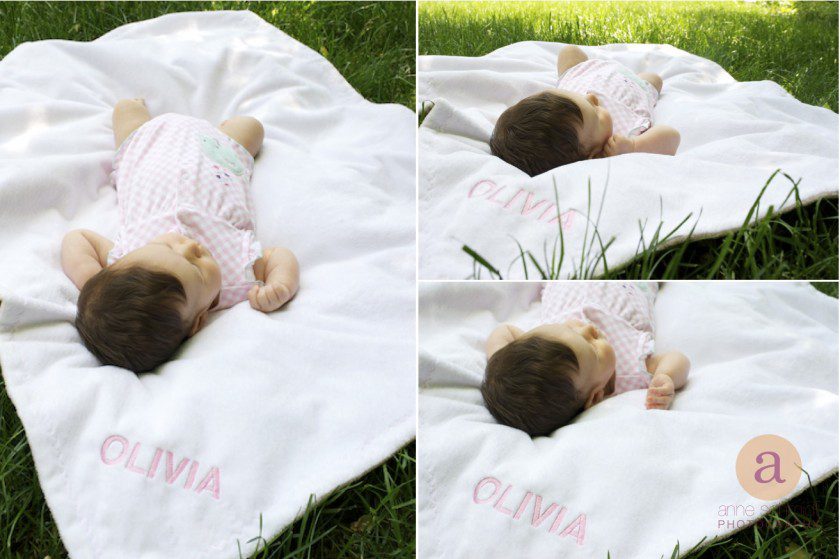baby laying on monogramed blanket