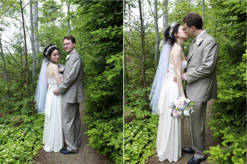 bride and groom walk through woodsy path