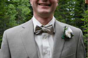 groom wears a bow tie with gray suit