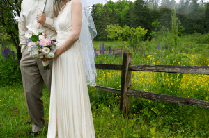 bride and groom at a roadside fence
