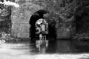 Maine engagement photo under stone train trestle