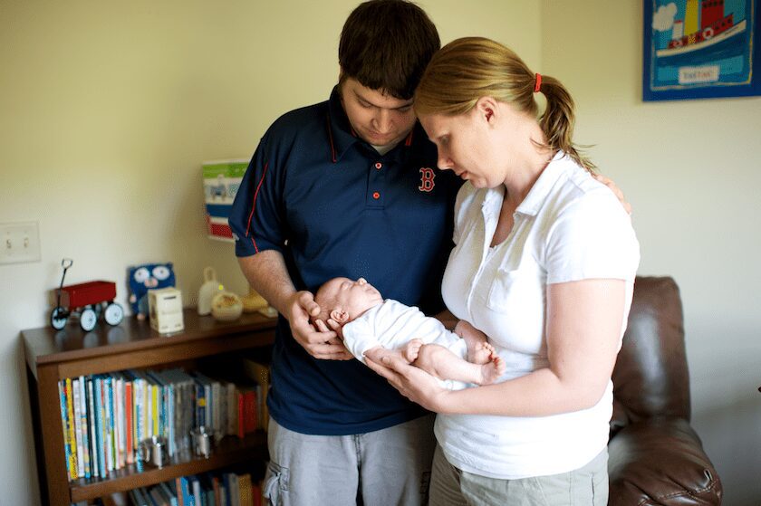parents holding baby
